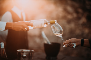 man pouring chardonnay inside a wine glass